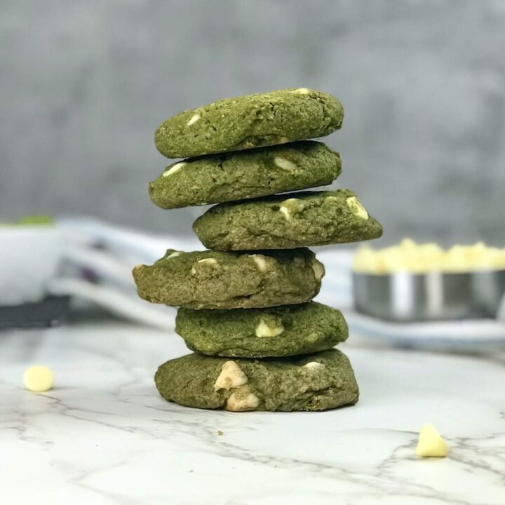 A stack of bright green matcha cookies with white chocolate chips.