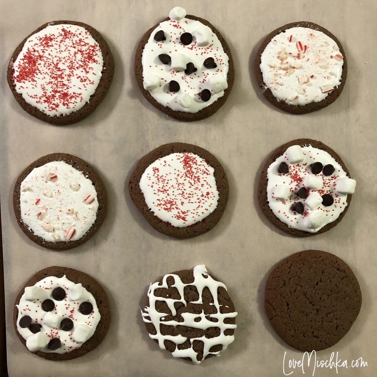 Nine Dark Brown Hot Chocolate Cookies on a sheet of parchment paper.