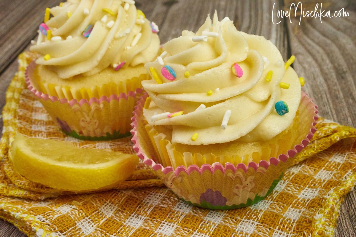 Easy Lemon Cupcakes from Scratch on a gold and white plaid cloth with a slice of lemon.