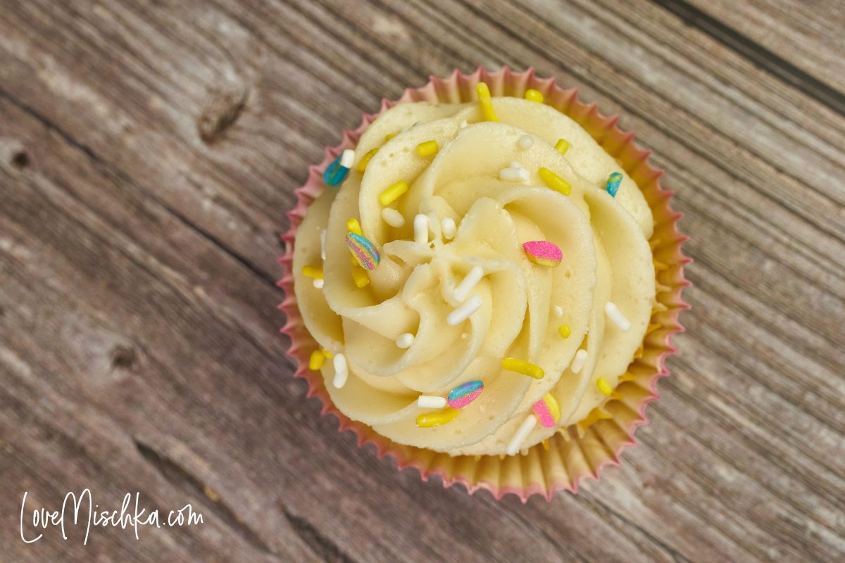 The top of a Lemon Cupcake from Scratch. Easter Sprinkles are on the swirl of buttercream.