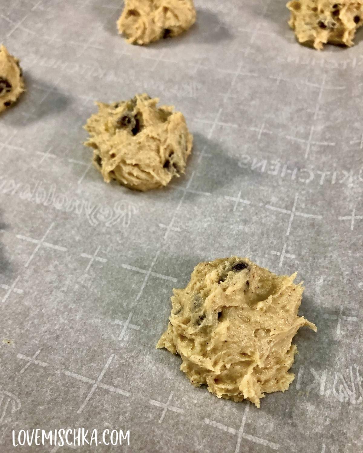 Balls of Banana Bread Cookie Batter on a parchment-lined baking sheet.