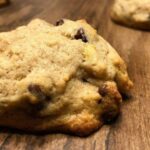 Soft Banana Bread Cookies with brown chocolate chips and yellow banana pieces on a wooden table.