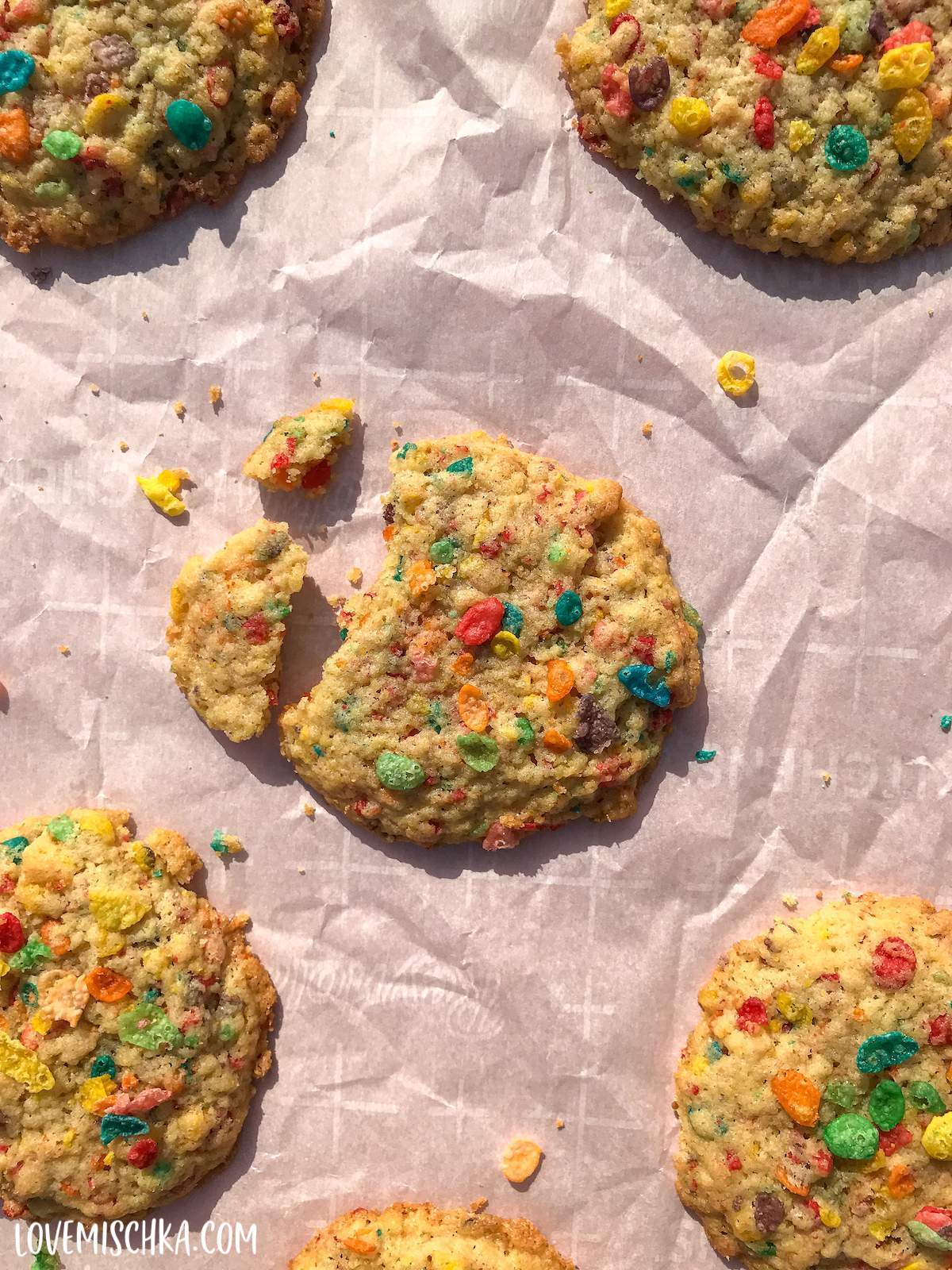 Fruity Pebbles Cookie Recipe cookies on a baking sheet lines with parchment paper.