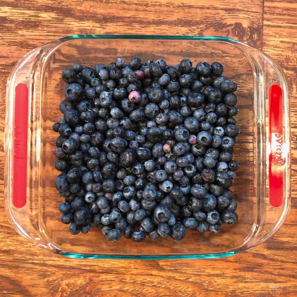 Fresh blueberries in a 9x9 glass baking dish in this easy blueberry crisp recipe.