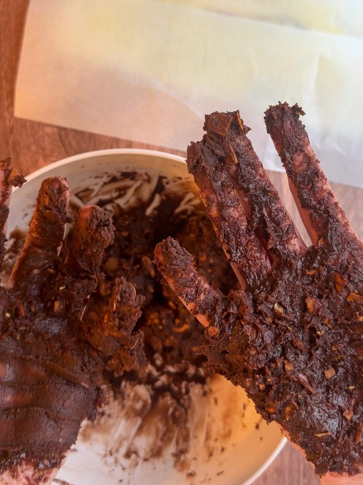 A pair of hands covered in thick, brown, extremely sticky chocolate cookie dough in this Italian Chocolate Cookies recipe. 